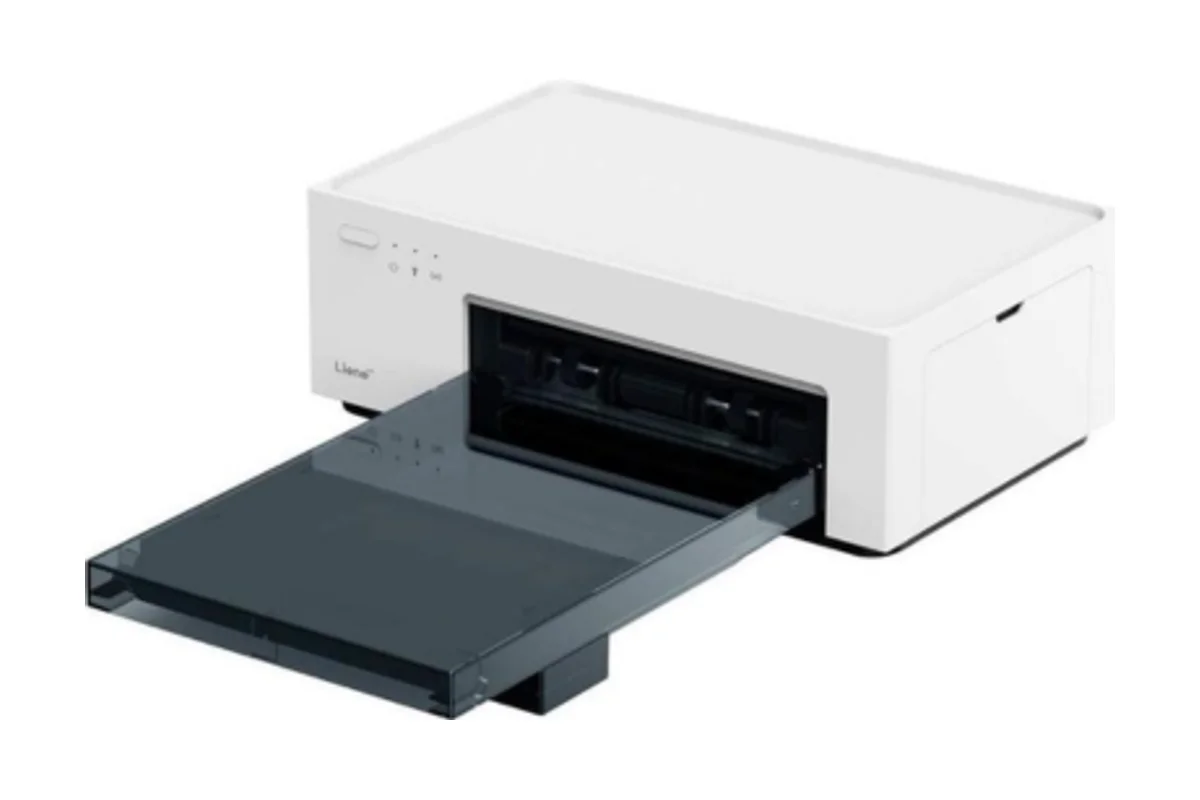 Impresora de fotos Liene Amber M100 blanca con la bandeja de papel gris transparente puesta, sobre fondo blanco